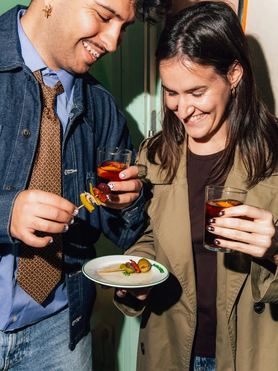 Una pareja con dos vermuts y un platito de banderillas y aceitunas de Casa Pepi